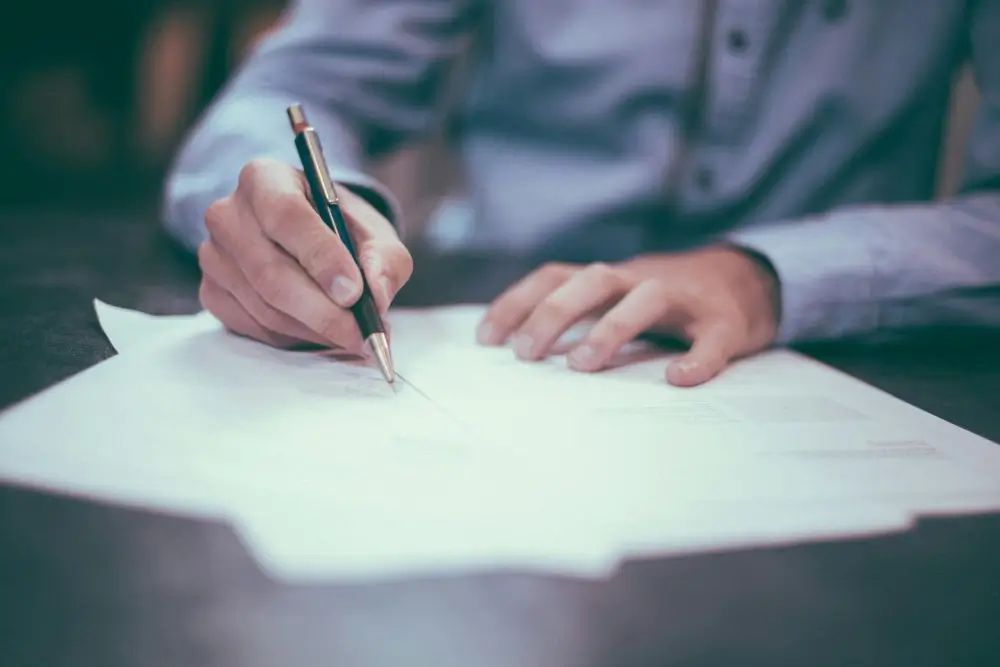 Hands signing a health law document