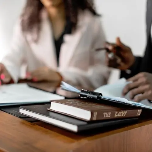 Attorney Emily Davis, litigation lawyer at Illumine Legal LLC, looking over legal document with pen at conference table