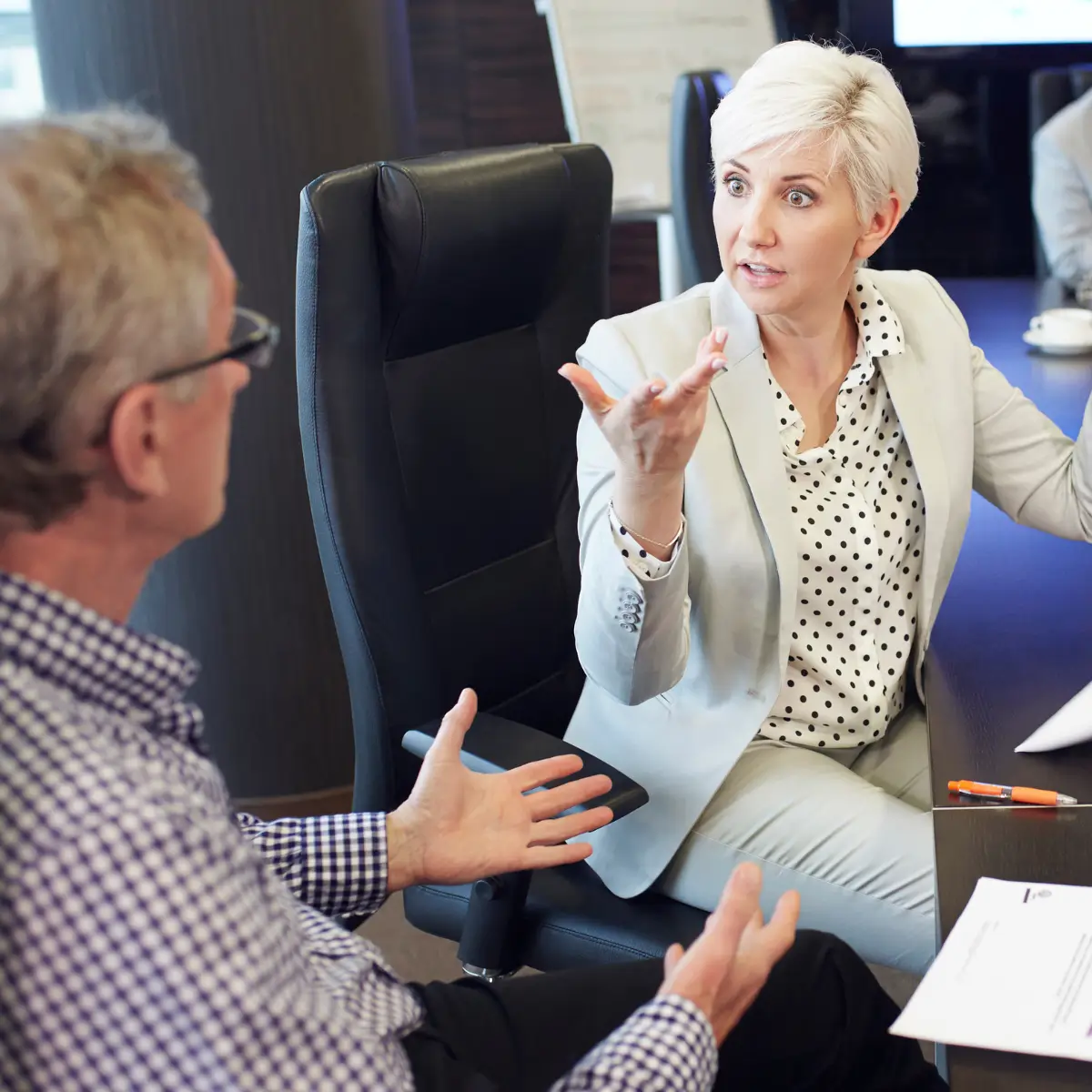 Partners Sitting at a Conference Table having a Corporate and Commercial Transaction Dispute