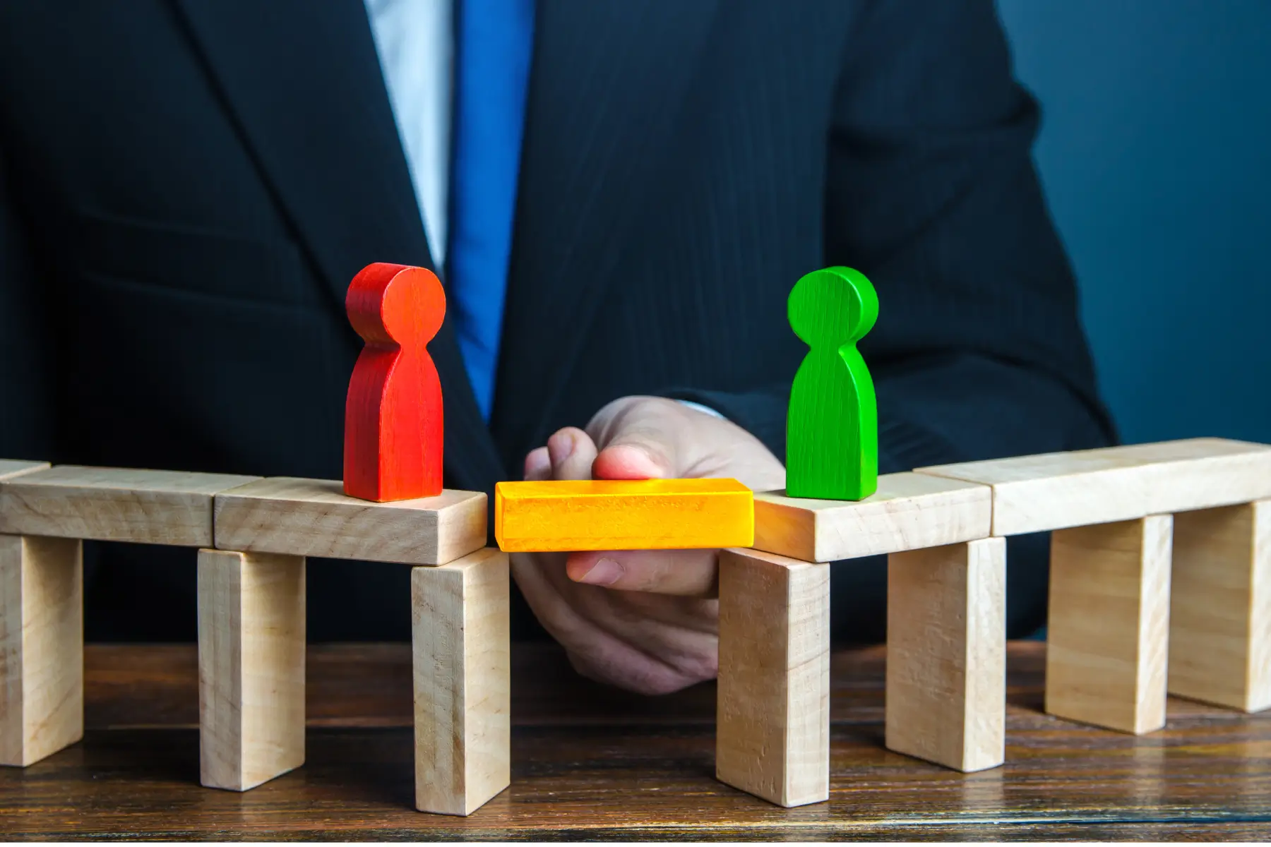 Lawyer arbitrating between two wooden clients by creating a bridge